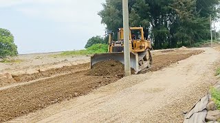 Working on the Road D6R Bulldozer Leveling Sand on Road Near the Sea