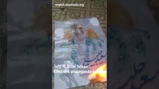 Protesters in Tehran set fire to elections propaganda poster