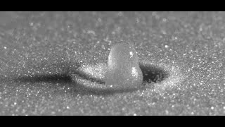 Slow motion water droplet impact on a sandy surface