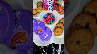 Filling platter with chocolate, cookies, sweets, candy salad, chips and more