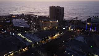 Flying over La Jolla Village and Seal Rock at dusk (San Diego, California) - 4K drone footage