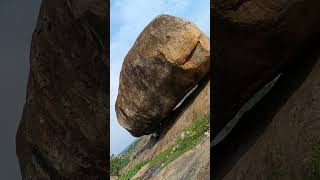 man sitted under giantic rock