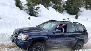 Jeep Grand Cherokee WJ crossing snow in mountain pass