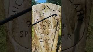 Cleaning the headstone of a veteran from the Spanish American War.